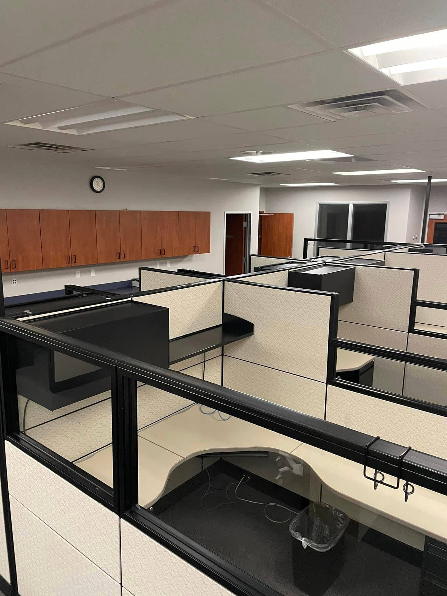 Cleaning crew vacuuming and wiping desks in an office in Omaha, NE